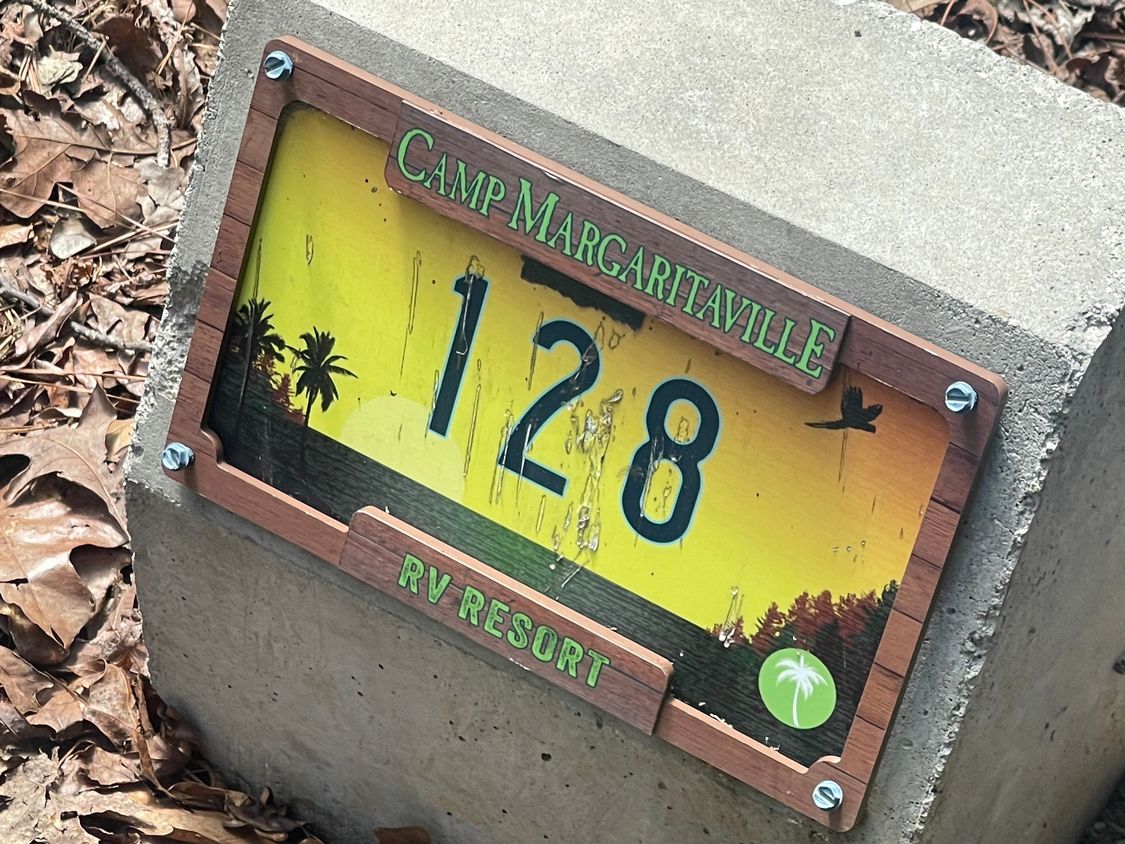 Camp Margaritaville RV Resort site marker number 128 with tropical sunset scene graphic