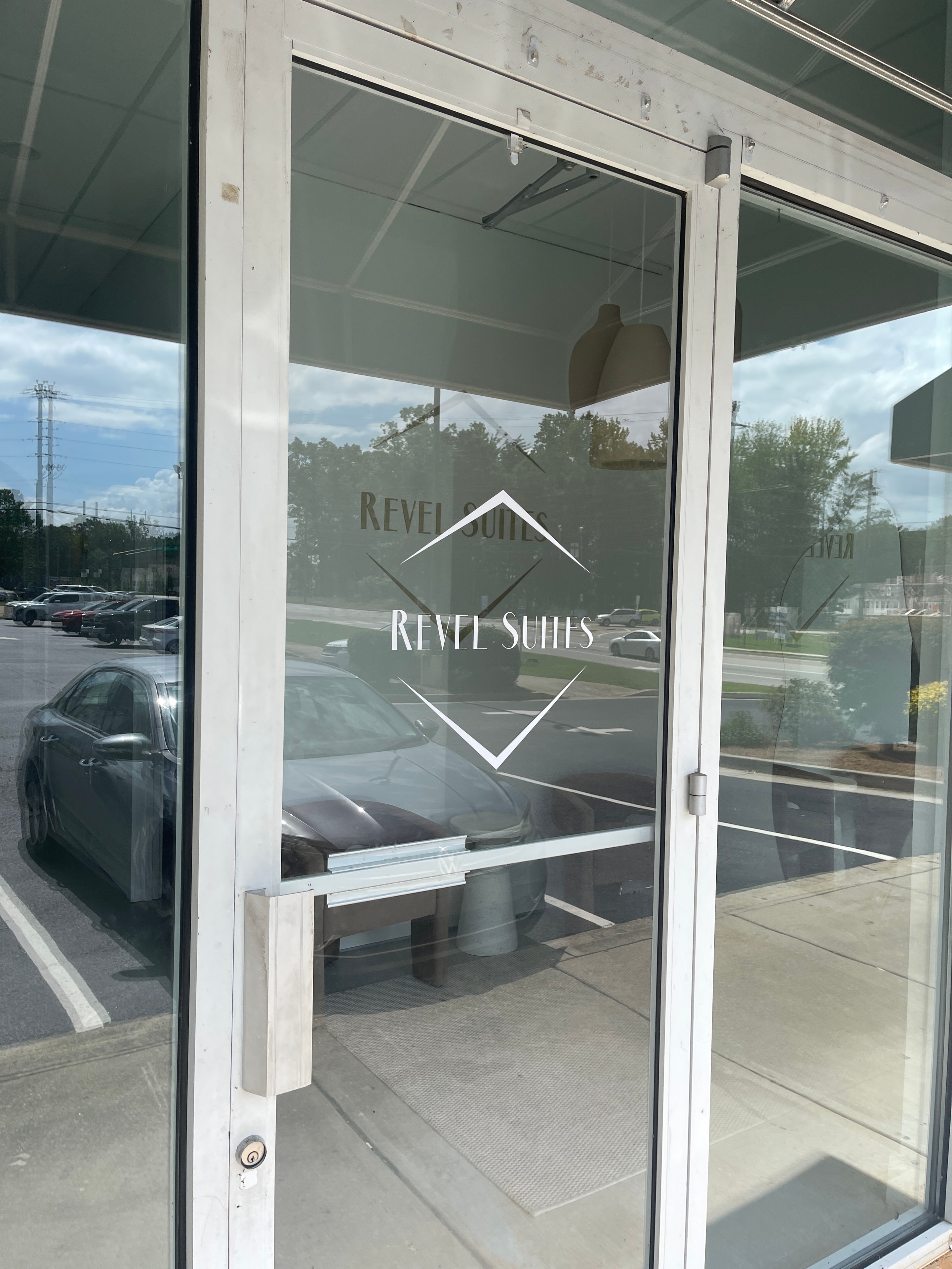 Revel Suites frosted vinyl logo graphics on commercial glass entry door